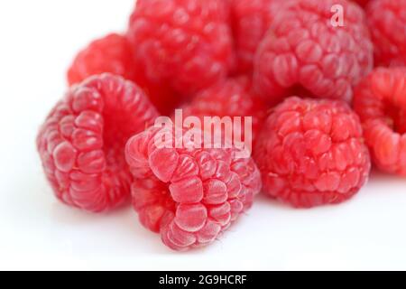 Red raspberry on white background. Pile of ripe berries close up, summer crop Stock Photo
