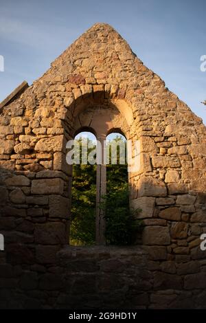 Abandoned house with the setting sun casting a beautiful orange glow on the remains. Stock Photo