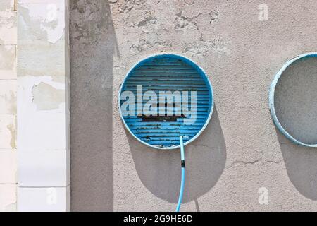 Round structures in a cement wall covered with cracked plaster. Stock Photo