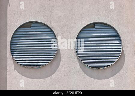 Round structures in a cement wall covered with cracked plaster. Stock Photo