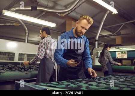 Experienced male shoemaker checks the patterns of shoes while working in the workshop. Stock Photo