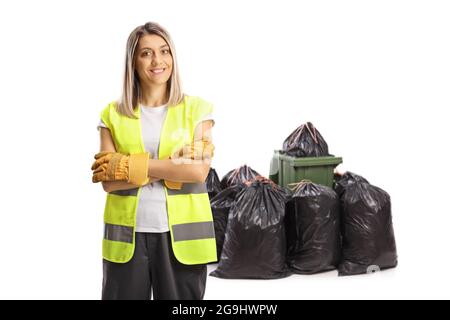 Woman waste collector in a uniform posing in front of a pile of bags isolated on white background Stock Photo