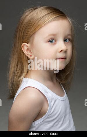 Cute little girl in white undershirt standing alone Stock Photo