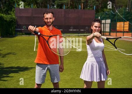 Two tennis players practicing a correct grip technique Stock Photo