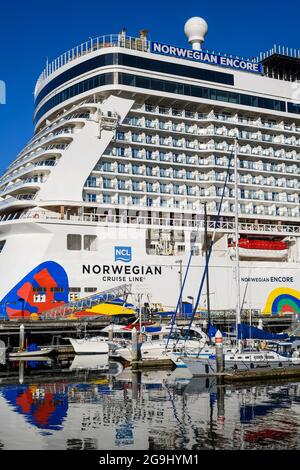 Seattle - July 25, 2021; Norwegian Cruise Line ship Norwegian Encore adding a colorful reflection with its stern  to the water at Seattle Pier 66 Stock Photo