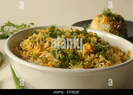 Steamed basmati rice tossed with a semi dry gravy of cottage cheese and bell peppers. Commonly known as Paneer rice in India. Shot on white background Stock Photo