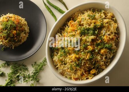 Steamed basmati rice tossed with a semi dry gravy of cottage cheese and bell peppers. Commonly known as Paneer rice in India. Shot on white background Stock Photo