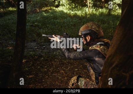 Soldier aiming with weapon at target on operation Stock Photo