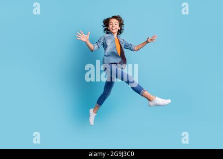 Full size profile side photo of young preteen boy happy positive smile go walk jump isolated over blue color background Stock Photo