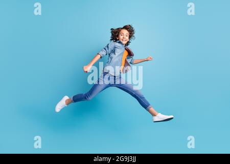 Full length profile side photo of young boy jump up go walk run isolated over blue color background Stock Photo