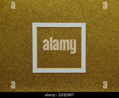 White paspart frame in the middle of the golden background, Creative layout, Space for text, Top view Stock Photo