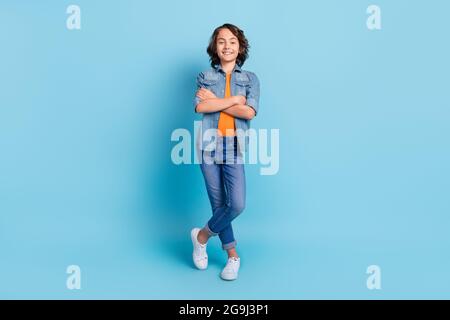 Full body photo of young preteen boy happy positive smile folded hands isolated over blue color background Stock Photo