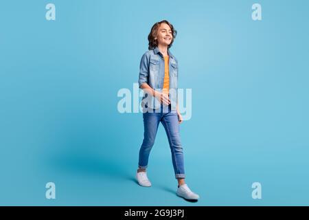 Full size profile side photo of young preteen boy happy positive smile go walk step isolated over blue color background Stock Photo