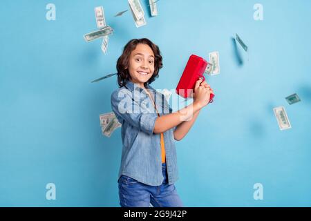 Profile side photo of young cheerful boy happy positive smile air fly cash money banknotes isolated over blue color background Stock Photo