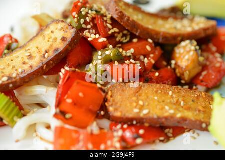Tasty food on a plate vegan grilled tofu and noodles with sesame Stock Photo