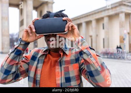 Germany, Berlin, Man using virtual reality goggles in city Stock Photo