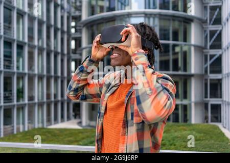 Germany, Berlin, Man using virtual reality goggles in city Stock Photo