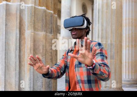 Germany, Berlin, Man using virtual reality goggles in city Stock Photo