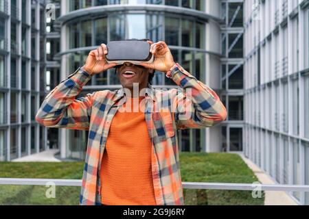 Germany, Berlin, Man using virtual reality goggles in city Stock Photo