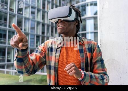 Germany, Berlin, Man using virtual reality goggles in city Stock Photo