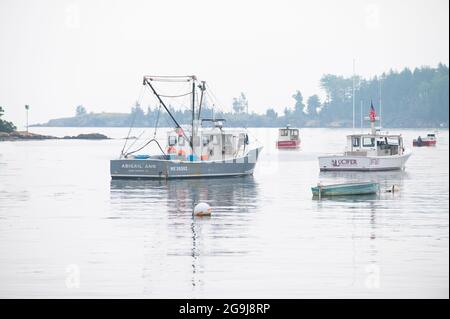 Commercial lobster boats at their moorings on a foggy morning in Owls Head, Maine, USA Stock Photo