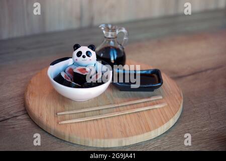 plate of sushi rolls with salmon made for children on wooden table with chopsticks and soya. korean food for kids Stock Photo