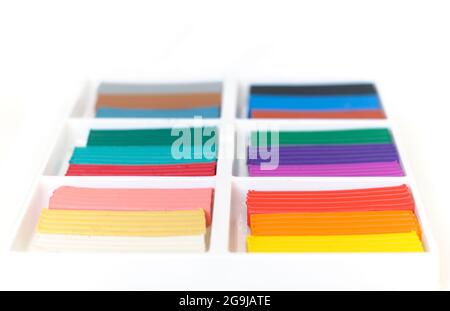 Open box with a new set of multi-colored plasticine. Multicolor plasticine blocks background Stock Photo
