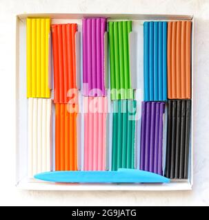 Open box with a new set of multi-colored plasticine. Multicolor plasticine blocks background Stock Photo