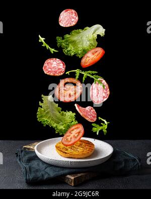 Creative concept with falling food on black backdrop Stock Photo