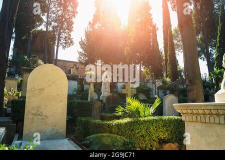 Beautiful European cemetery on sunny day with gravestone in foreground without inscription as copy space for text. Stock Photo