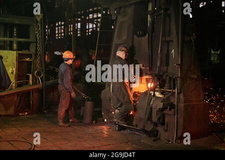 Worker in protective workwear operating at the metallurgical plant Stock Photo