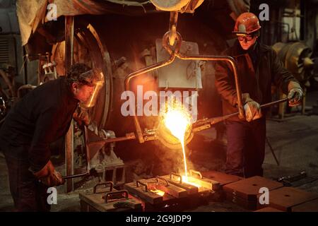The welder works in the factory shop two steel workers melting metal Stock Photo