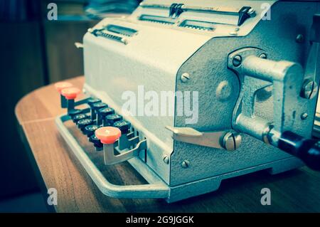 Vintage mechanical adding machine on table Stock Photo