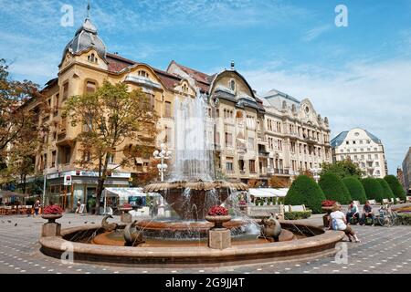 TIMISOARA, ROMANIA - JULY 29, 2015: fountain with fishes and elegant  buildings in Victory Square of Timisoara. Stock Photo