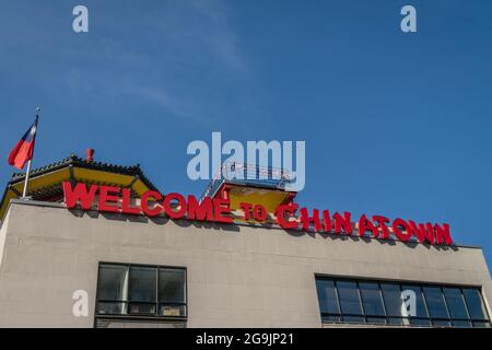 Welcome to Chinatown sign in Boston's Chinatown against bright blue sky. Stock Photo