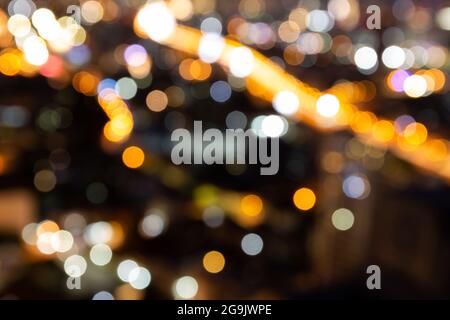 Blur bokeh background with cityscape in twilight, blurred focus in evening with downtown, landscape, illuminated and light. Stock Photo