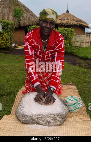 Woman preparing local bread at a ceremony of former poachers, in the Virunga National Park, Rwanda, Africa Stock Photo