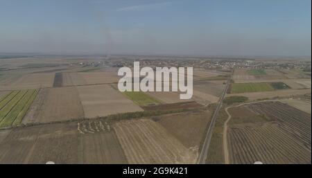 Vast plane Vojvodina crops burning in the distance aerial drone shot. Stock Photo