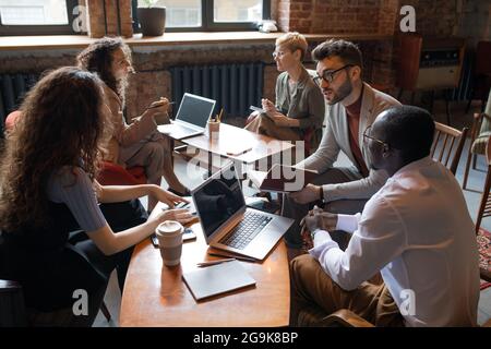 Two groups of co-workers discussing new ideas at meeting Stock Photo