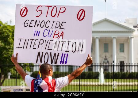 Washington, DC, USA, 26 July 2021.  Pictured: A protester holds a sign in front of the White House at the end of the Cuban Freedom March demanding that the US intervene to stop genocide in Cuba.  Hundreds of Cuban Americans from around the United States came to Washington for the march, demanding that the Biden Administration intervene to remove President Miguel Diaz-Canel and restore freedom to Cuba.  The march took place on Día de la Revolución, the anniversary of the 1959 revolution that brought Fidel Castro to power.  Credit: Allison Bailey / Alamy Live News Stock Photo