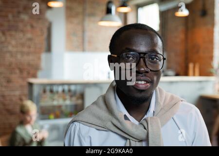 Confident African businessman in eyeglasses standing in front of camera Stock Photo