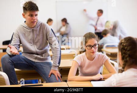 Teenage students talking during recess between lessons Stock Photo