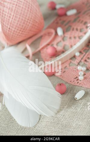 DIY composition of handmade dream cathcer assembling. White feathers, pearls, pink beads and threads Stock Photo