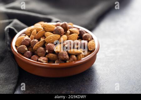 Peeled hazelnuts and almonds. Sweet nuts in bowl. Stock Photo