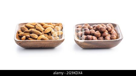 Peeled hazelnuts and almonds. Sweet nuts in wooden bowl isolated on white background. Stock Photo