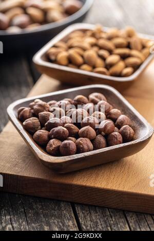 Peeled hazelnuts and almonds. Sweet nuts in wooden bowl. Stock Photo