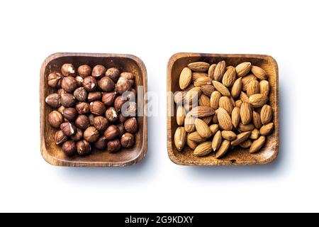 Peeled hazelnuts and almonds. Sweet nuts in wooden bowl isolated on white background. Stock Photo