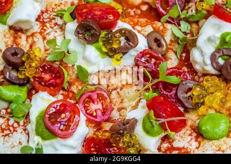 Gourmet Pizza Surface with Burrata, Balsamic Pearls, Cherry Tomatoes, and Pesto Stock Photo