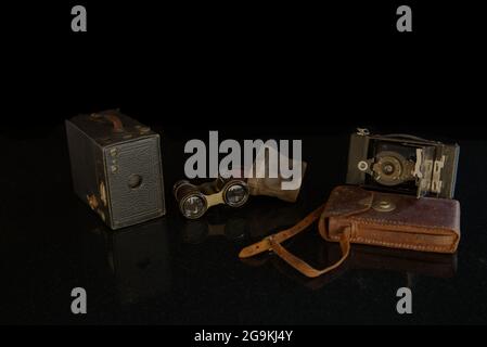 Still life Cameras and binoculars on black background Stock Photo