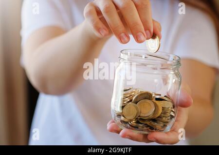 Turkish lira banknotes and coins in glass jar,woman hand. The paper currency of Turkey. Current Turkish liras are issued by The Central Bank of the Re Stock Photo
